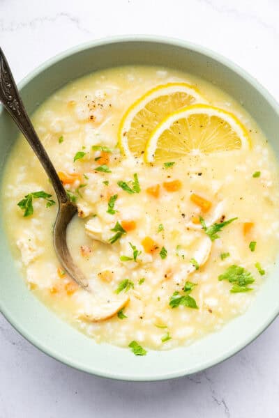 Bowl of avgolemono soup with fresh lemon slices