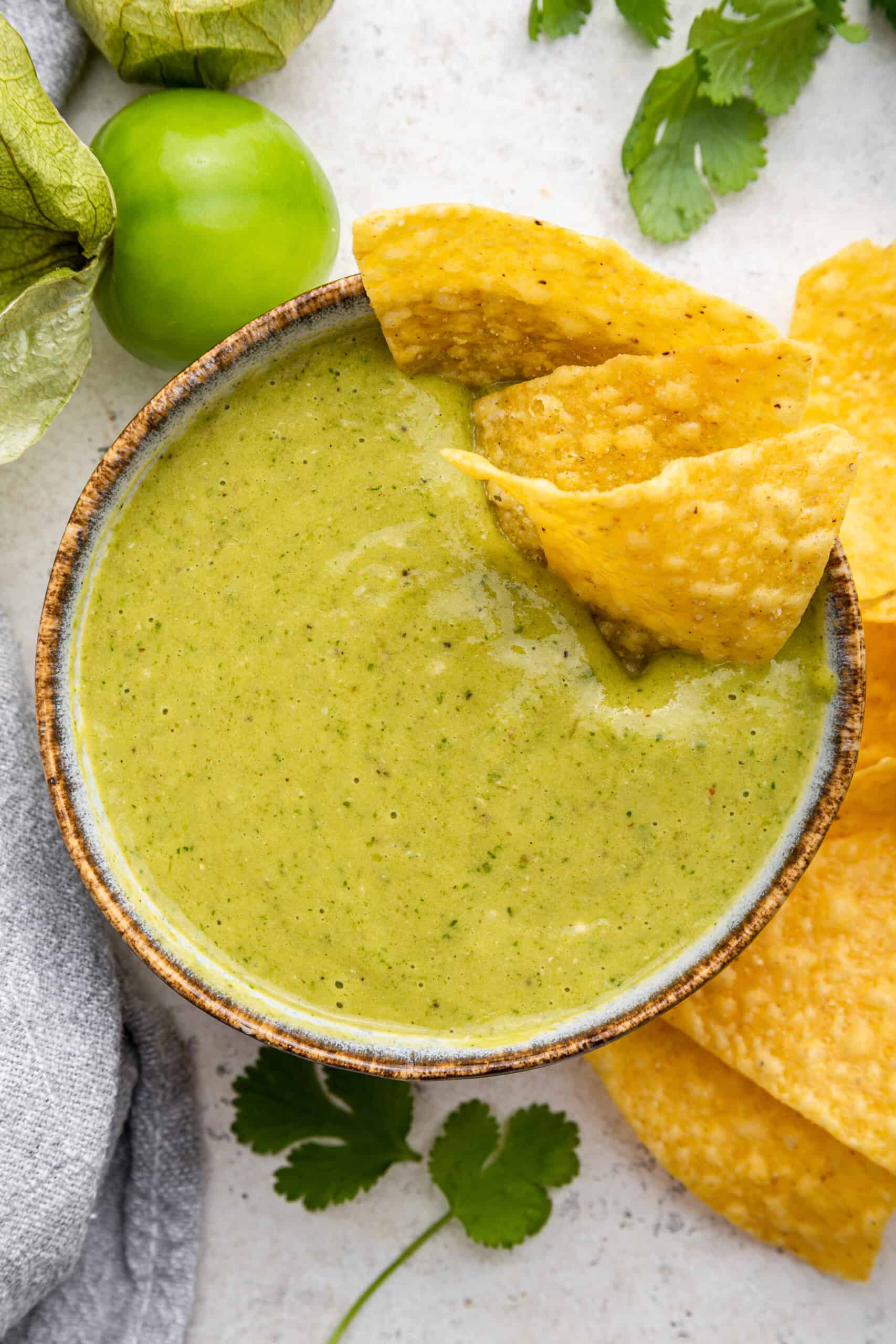 This roasted tomatillo salsa recipe is made with just a handful of ingredients and a few easy steps. Tangy, smoky, and so delicious! Tomatillo salsa in bowl with tortilla chips