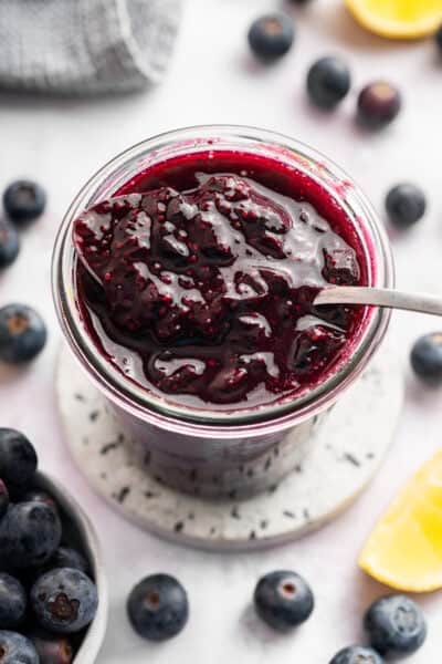 Spoonful of blueberry compote in jar.