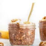 Chocolate overnight oats in a small glass jar with a spoon.