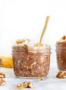 Chocolate overnight oats in a small glass jar with a spoon.