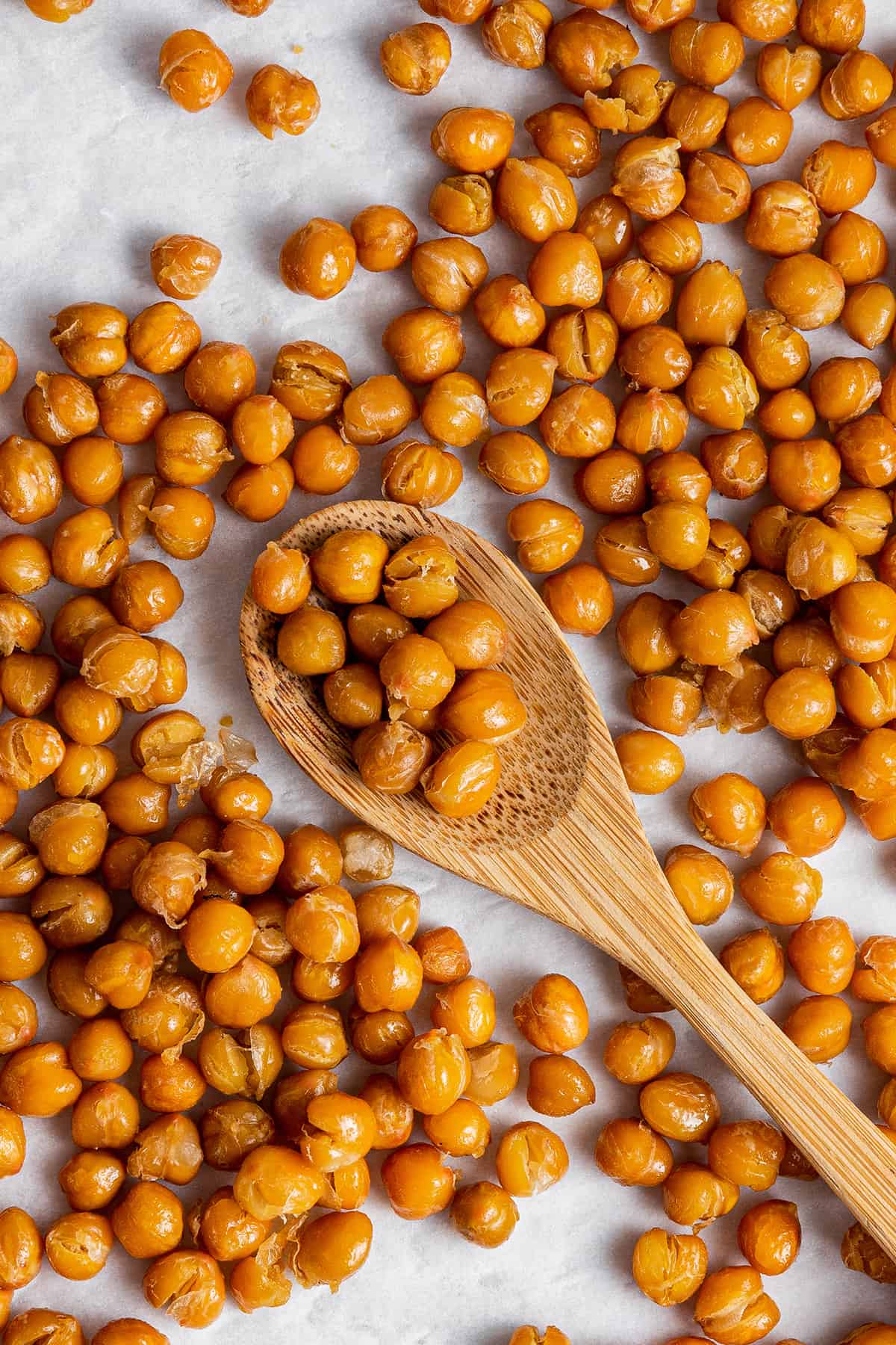 Find your new favorite chickpea recipes for every meal! From soups to salads and more, these dishes are easy and packed with plant protein. A counter full of crispy chickpeas, with a wooden spoon in the middle with chickpeas.