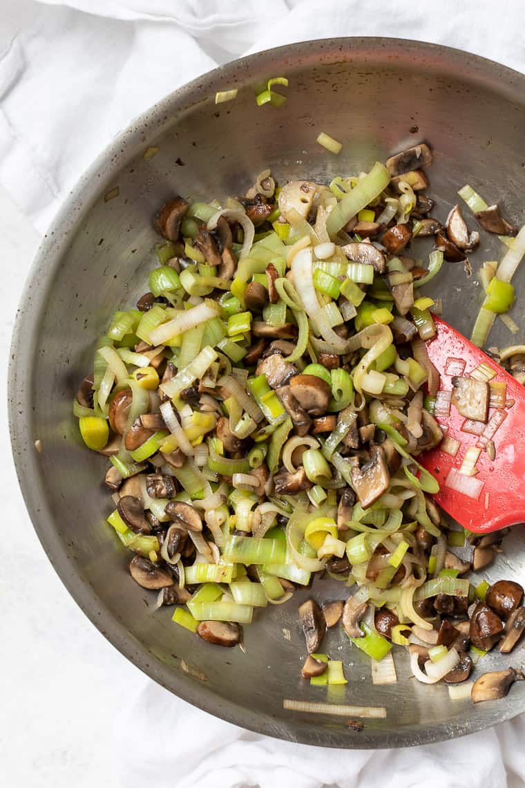 Cooking mushrooms and leeks in skillet
