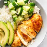 Bowl with harissa honey chicken, white rice, cucumber, and avocado.