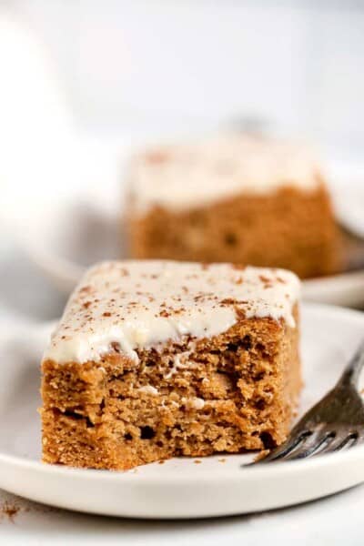 A slice of gluten free apple cake on plate with a forkful missing from the corner.