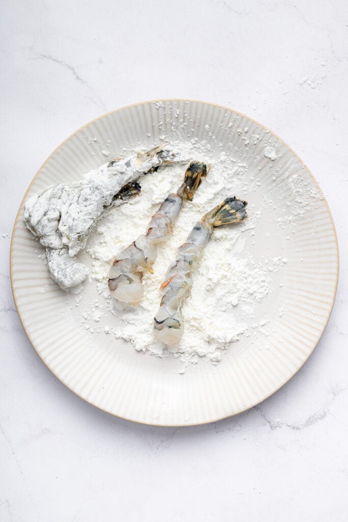 This crispy shrimp tempura is perfectly golden and just as crispy and delicious as the restaurant version. Only six ingredients! Coating shrimp in cornstarch on plate