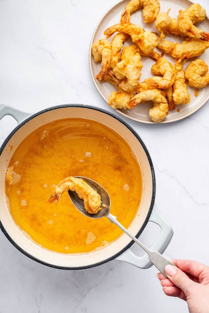 Dredge them in cornstarch. Generously sprinkle cornstarch on your shrimp until they’re completely covered. Shake off any excess. Using spoon to remove shrimp tempura from pot of oil