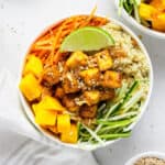 overhead of teriyaki quinoa bowls with mango, tofu and sesame dressing